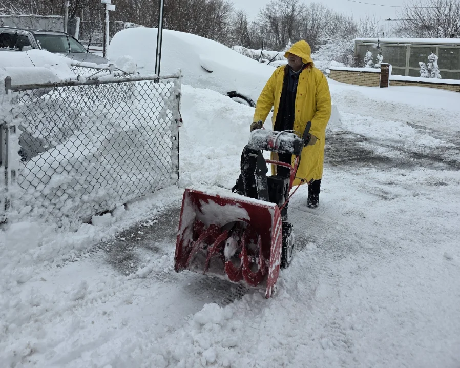 Greenscape crew member clearing deep snow with a snowblower